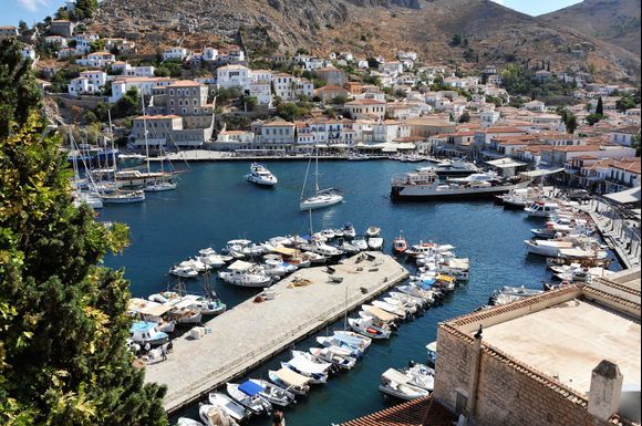 Overview of the beautiful harbor on Hydra and boats of all sizes.