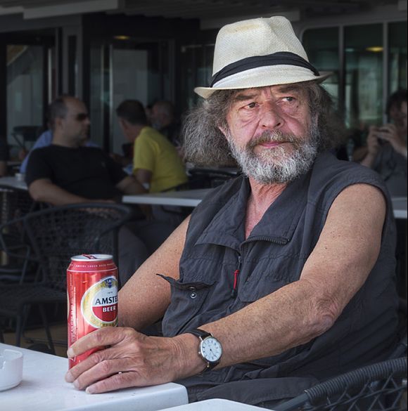 Man with Amstel beer and white hat, on board a Blue Star ferry.