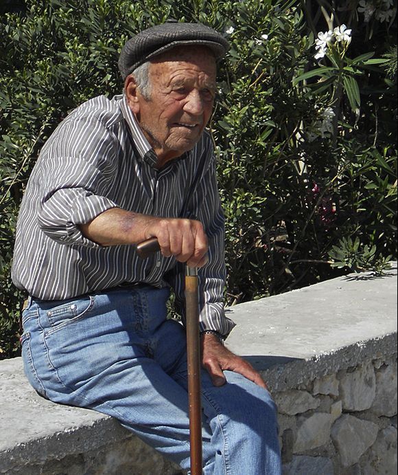 Man sitting on wall behind Ag. Nikolaos church, Parikia