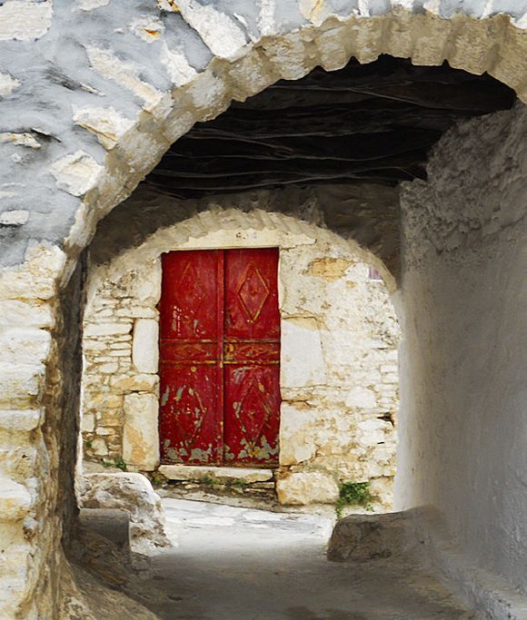Red door and arch in Aperathos