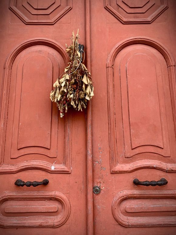 Pretty dried flowers adorn as grand old doorway
