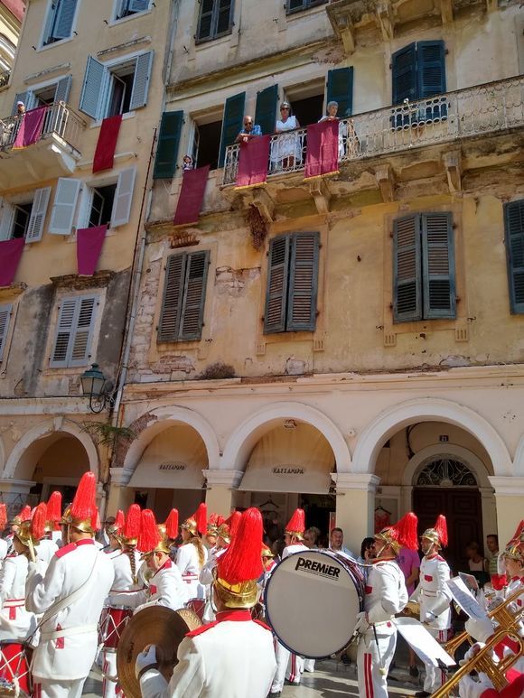 In this picture you can see one of the bands of  Corfu playing a   
march and the red cloth that it hanging from the windows of the buildings which is a custom in Corfu!
