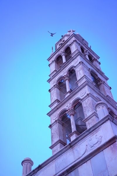 Just caught the bird flying off the clock tower at dusk