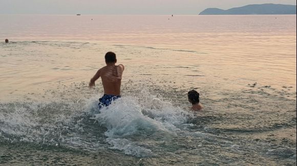san antonio beach , happy kids running to sea under the sunset in potos