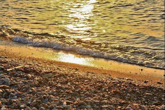 Pebbles, waves and rays of sun