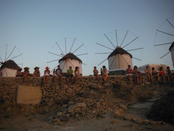 Windmills with people watching sunset
