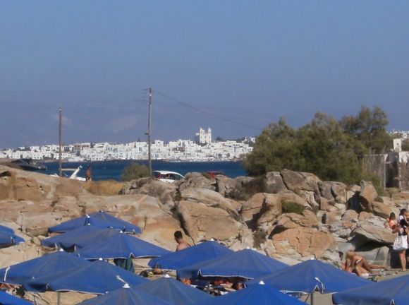 Umbrellas among the rocks with the white  Naoussa on the background