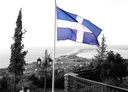 Greek flag and view from Agios Ioannis Lefkada.