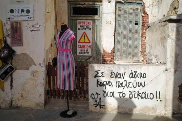 Street scene from Naxos town. Can someone translate the writing on the wall for me please. I hope it's nothing bad. Thanks a lot.