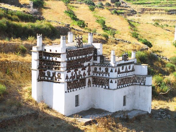 The <b>island of Tinos</b> is famous for the many intricately designed <b>dovecotes</b> found here. They are fortress-like stone structures with two levels decorated with both geometric patterns including triangles and rhomboids and non-geometric patterns including cypress trees and variations of the sun. It is believed that these elaborate patterns are the reason why the pigeons are attracted to these dovecotes. Most of these structures are found in the eastern and central parts of Tinos and the oldest ones are believed to be from the 18th and the 19th Century. 
More about Tinos here:  https://www.greeka.com/cyclades/tinos/ 