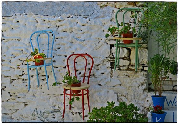 29-08-2022 Andros: Gavrio .........Chairs with plants on a wall