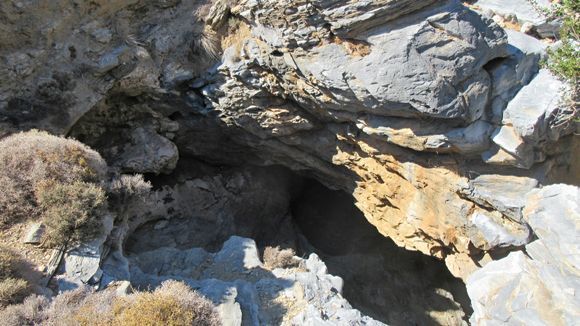 A large hole to the inside of a rugged cave