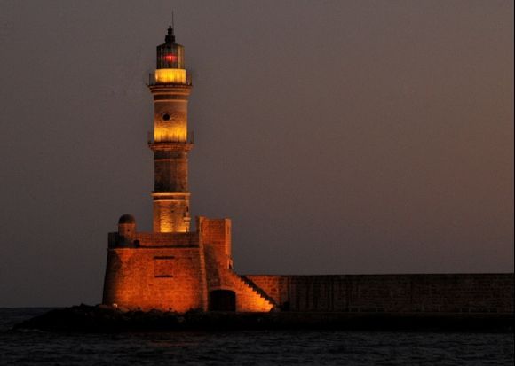 Chania Venetian lighthouse lit up at night.
