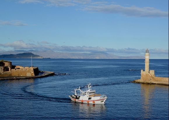 A fishing boat returns to Chania old harbor.