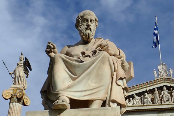 Statue of Plato with statue of Athena behind and to the left outside the Academy of Athens.
