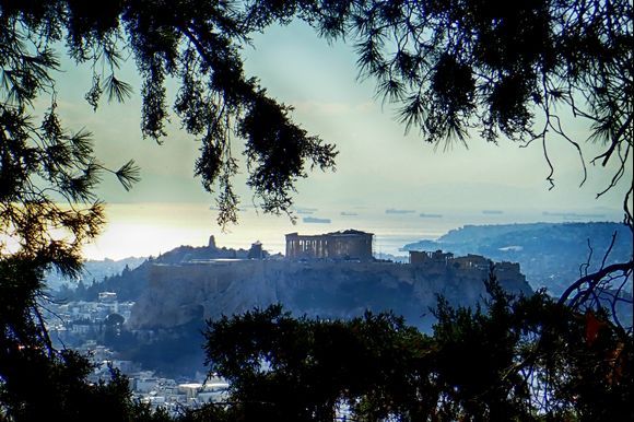 View of the Acropolis taken from Mount Lycabettus. In the distance are cargo ships moored in the Sarconic Gulf outside Pireaus Port. 