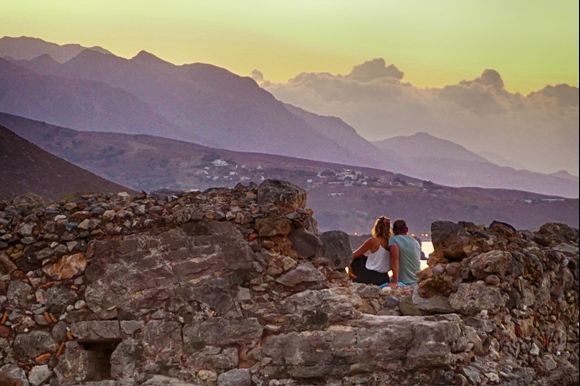 A couple soak in the rugged beauty of dawn from the ruined Venetian castle (Kastela) overlooking the entrance to Loutro Bay