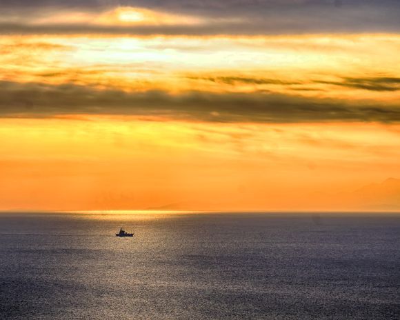 A fishing boat returning to Souda Bay after sunrise.