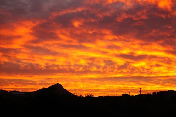 A fiery sunrise fills the sky behind Mount Skloka on the Akrotiri.