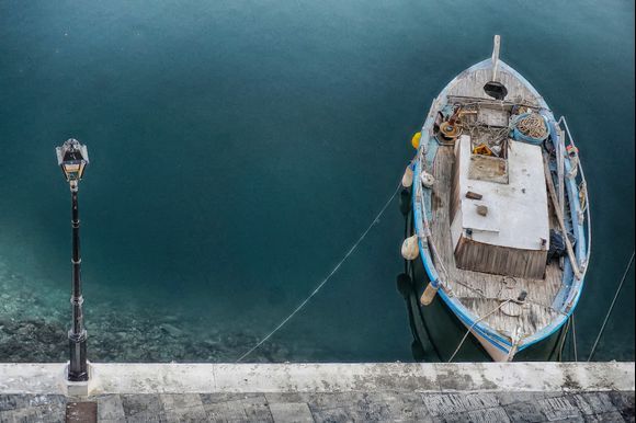 A fishing boat with muted colors and lots of character moored in Agios Nikolaos' sea lake.