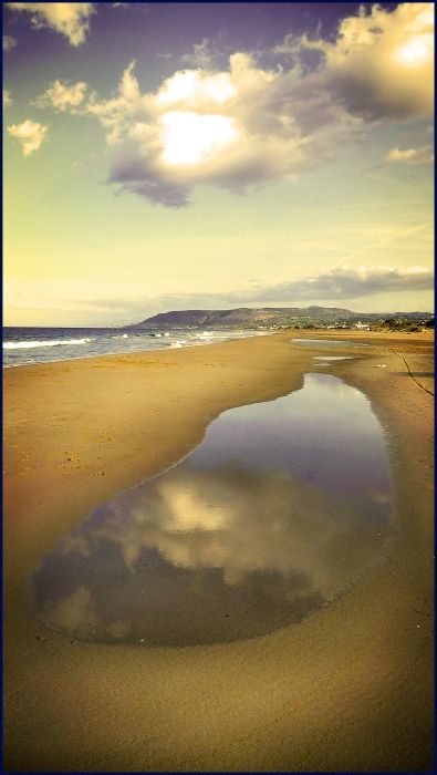 After the rain there is a big puddle on the beach, in which the clouds are reflected