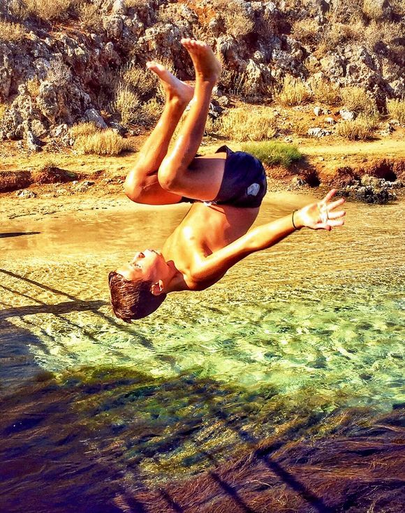A boy is making a salto into the Almyros river in Georgioupolis, Crete.