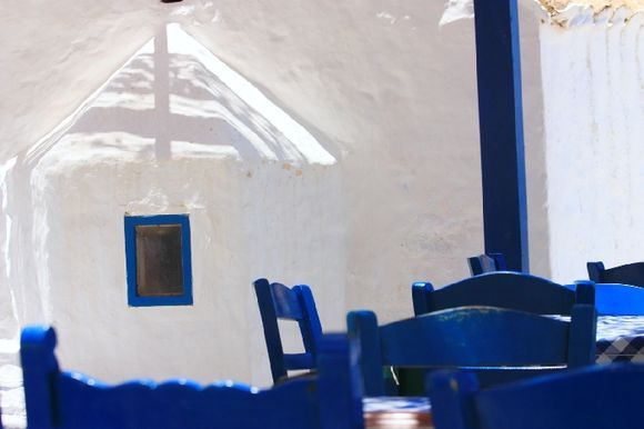 White church, blue wooden chairs, Mandraki