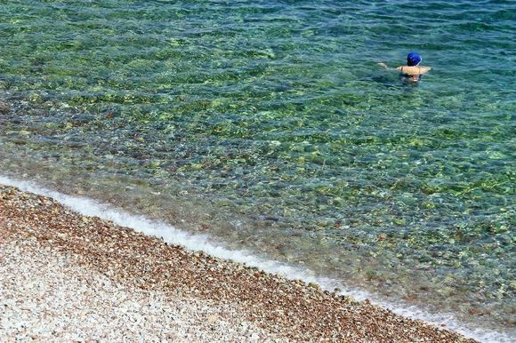 Crystal clear water and swimmer with a blue hat, Vlyhos