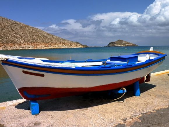 Freshly painted wooden fishing boat by the sea in Panormos bay