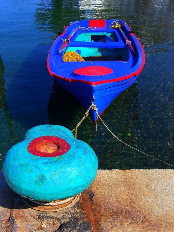 Boat tied to a blue bollard, Skala
