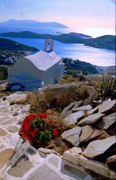Scenery with steps, flowers and cute chapel on top of Chora hill overlooking the sea