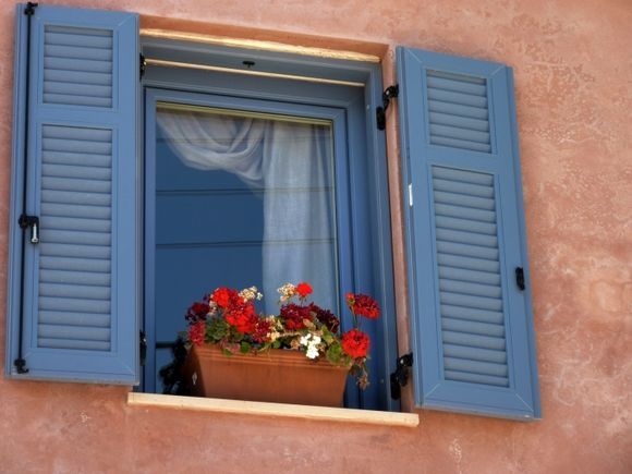 Pink facade with blue window and geranium