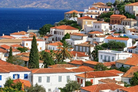 Hydra\'s mansions with red-tiled roofs and Aegean sea