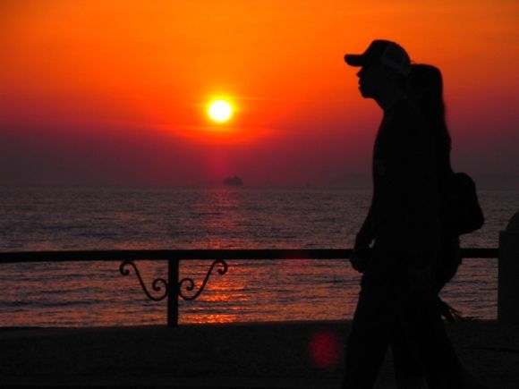 Silhouette of couple walking on the waterfront at sunset, Rhodes town