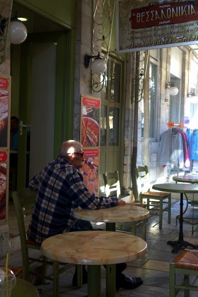 A man sitting at a kafenio at the market, Xiou street