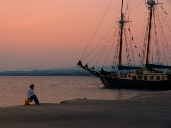Girl at sunset and traditional four-masted boat