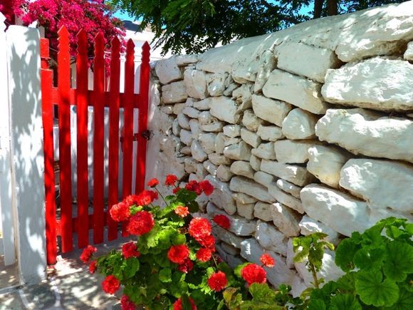 Red wooden gate and whitewashed stone wall