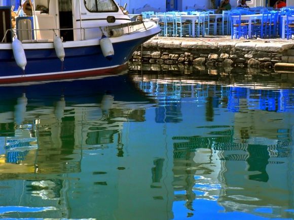 Seaside taverna and boat reflected in the water