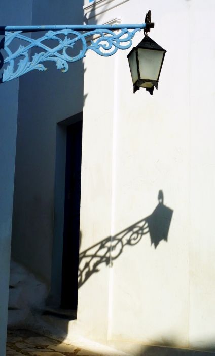 Narrow alley with lamp post and reflection