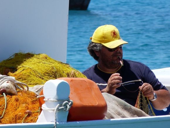 Fisherman with a yellow cap mending