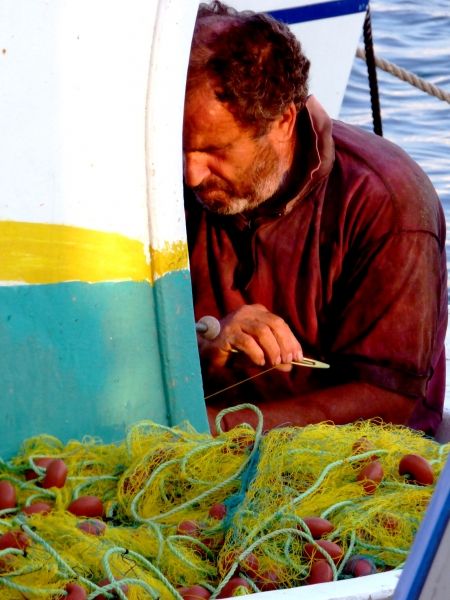 Closeup view of fisherman mending nets