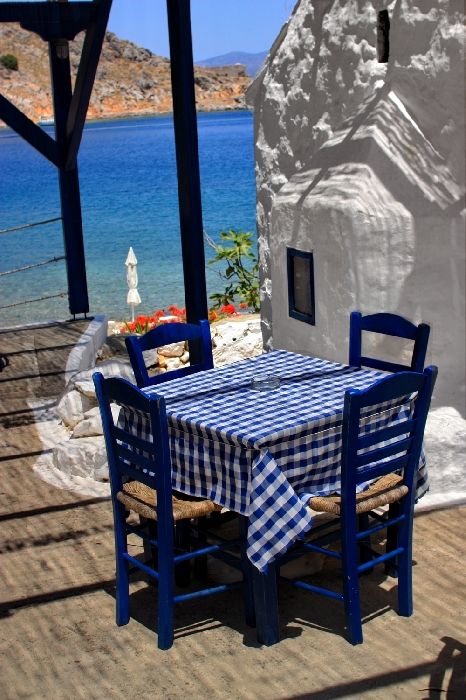 Taverna\'s table with whitewashed chapel. Mandraki