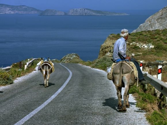 Man riding a donkey on Ano Meria scenic road