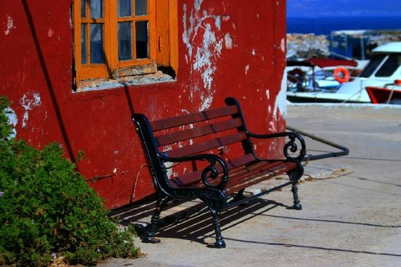 Kaminia harbour with red facade and bench