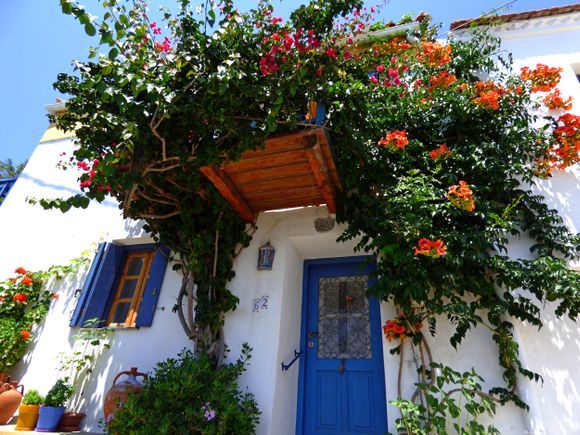 House and wooden balcony filled with bougainvillea, Chora