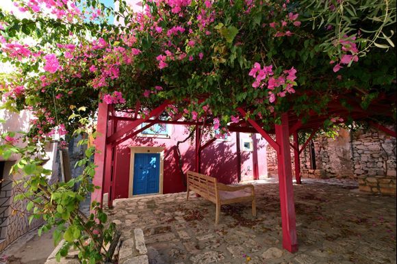 Colorful square with pink house and bougainvillea, Kastellorizo island, Dodecanese