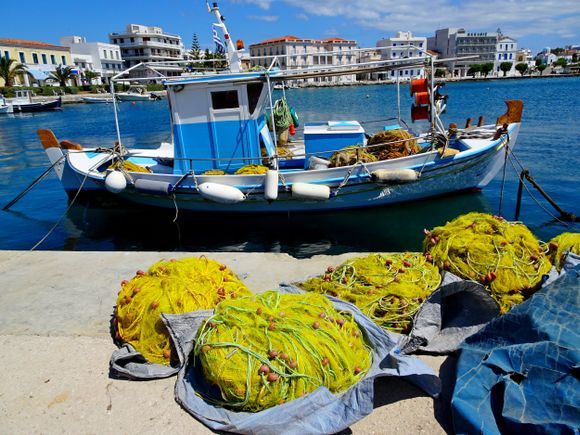 Port with fishing boat and fishnets, Tinos town