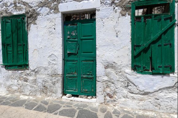 Decayed facade with green door and windows, Tripiti