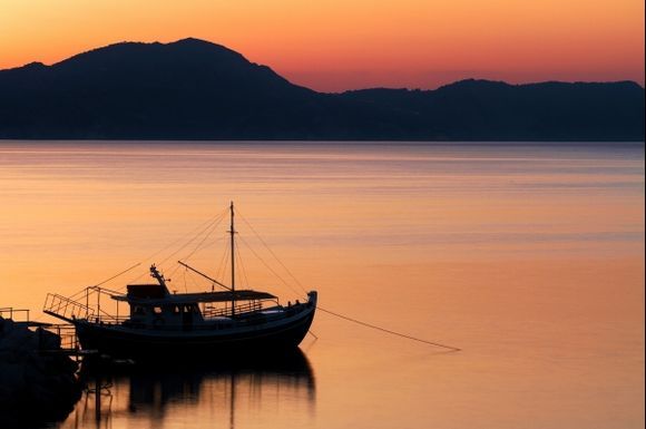 A fishing boat moored in the port at dawn.