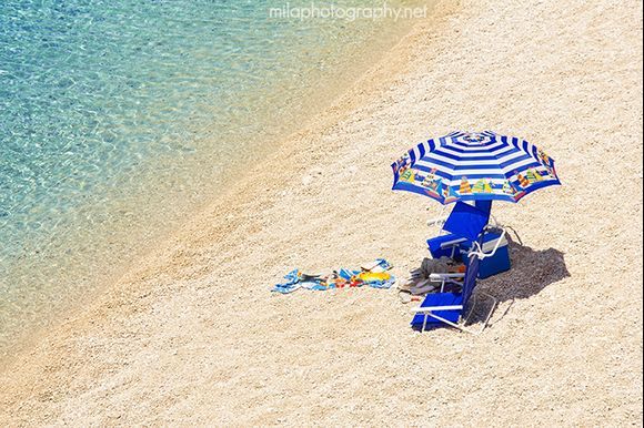 Blue lounge chair with umbrella on the beach